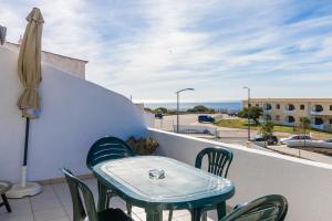 stół i krzesła na balkonie z widokiem na ocean w obiekcie Apartment Centeanes Sol w mieście Carvoeiro