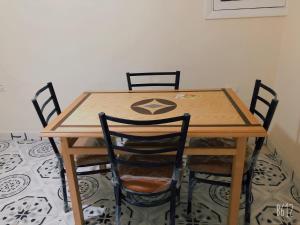 a wooden table with four chairs around it at Apartment near Abdeen Palace & Museum in Cairo