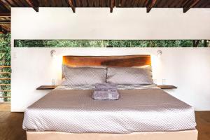 ein Schlafzimmer mit einem großen Bett mit einem hölzernen Kopfteil in der Unterkunft The Mimosas - Beautiful Unique Container Homes with Pool in Hone Creek