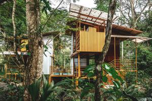 ein Baumhaus mit einer Terrasse im Wald in der Unterkunft The Mimosas - Beautiful Unique Container Homes with Pool in Hone Creek