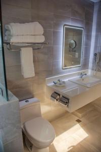 a bathroom with a toilet and a sink and a mirror at Best Western Plus Hotel Stofella in Guatemala