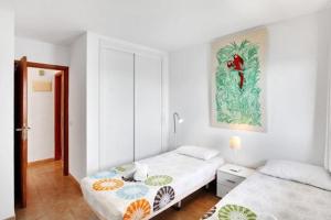 sypialnia z dwoma łóżkami i obrazem na ścianie w obiekcie Costa Isora Frontline & Pool By Paramount Holidays w mieście Puerto de Santiago