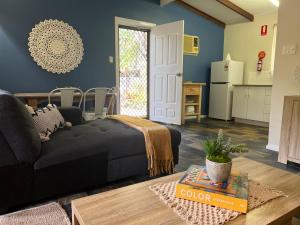 uma sala de estar com um sofá preto e uma cozinha em Colonial Village Resort em Hervey Bay