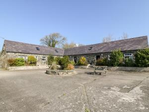 a stone building with a bench in front of it at Bwthyn y Dderwen Oak Cottage in Llannor