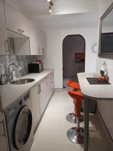 a kitchen with a sink and a washing machine at Pleasure beach apartment with garden in Skegness