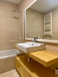 un bagno con un lavandino, uno specchio e una vasca di Apartamento O Albuquerque - Centro Cidade Alcobaça ad Alcobaça