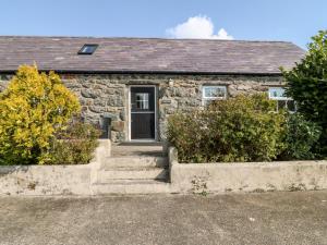 ein Steinhaus mit einer Treppe davor in der Unterkunft Bwthyn yr Onnen Ash Cottage in Llannor