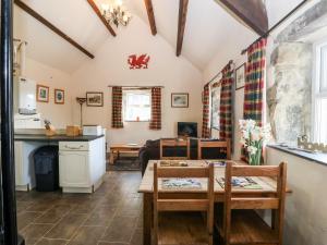 eine Küche und ein Wohnzimmer mit Tisch und Stühlen in der Unterkunft Bwthyn yr Onnen Ash Cottage in Llannor + 8 Fotos