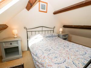 ein Schlafzimmer mit einem Bett und zwei Nachttischen in der Unterkunft Bwthyn yr Onnen Ash Cottage in Llannor