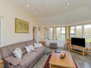 a living room with a couch and a tv at Clock Tower Cottage in Great Bedwyn