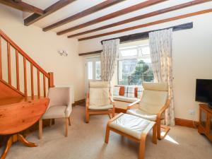 ein Wohnzimmer mit 2 Stühlen und einem TV in der Unterkunft Manna Cottage in Grassington