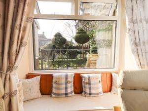 a window seat with pillows in front of a window at Manna Cottage in Grassington