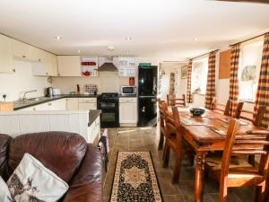eine Küche und ein Esszimmer mit einem Tisch und Stühlen in der Unterkunft Bwthyn yr Helyg Willow Cottage in Llannor
