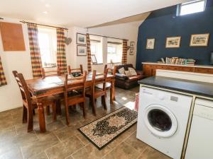 eine Küche und ein Esszimmer mit einem Tisch und einer Waschmaschine in der Unterkunft Bwthyn yr Helyg Willow Cottage in Llannor
