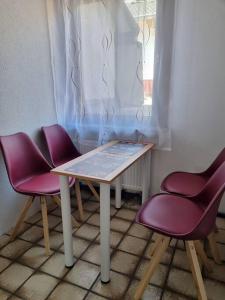 uma mesa e duas cadeiras sentadas ao lado de uma janela em KM2 Apartment em Triberg