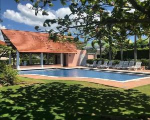 a swimming pool with chairs and a gazebo at Villa Angela in Playa Blanca