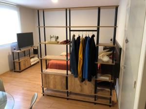 um quarto com uma prateleira com casacos e uma televisão em Departamento en la mejor ubicación de Mendoza con estacionamiento opcional em Mendoza