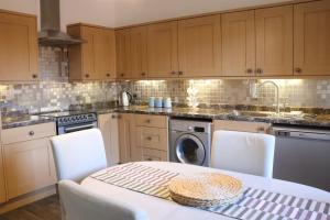 a kitchen with a table and a washing machine at East Nook in Anstruther