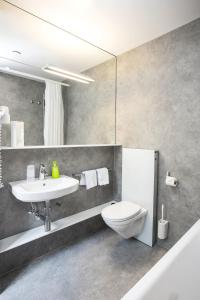 ベルンにあるホテル ヴァルトホルンのバスルーム(洗面台、トイレ、鏡付)
