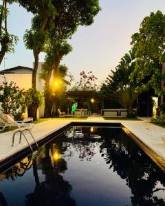 una piscina en un patio con árboles en Villa Ostello Pousada en Paripueira