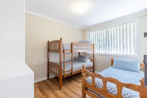 a room with two bunk beds and a window at 3 Fingal Court in Fingal Bay