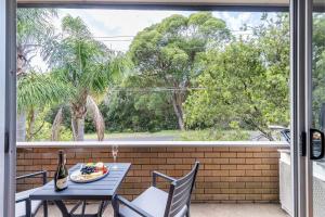 a patio with a table and chairs and a window at 3 Fingal Court in Fingal Bay