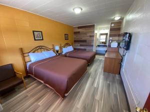 a hotel room with two beds and a television at Dauphin Inn Express in Dauphin