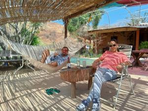 un hombre y una mujer sentados en una hamaca en Hotel SPA Campestre Los Adobes en Taxco de Alarcón