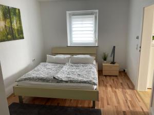 a bedroom with a bed and a window at Kosumi Apartment in Kolbermoor