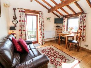 a living room with a leather couch and a table at Heath Cottage in Edale