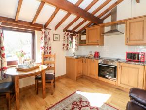 cocina con armarios de madera y mesa en Heath Cottage en Edale