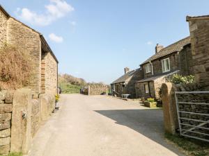 an empty street in a village with brick buildings at Heath Cottage in Edale +11 photos