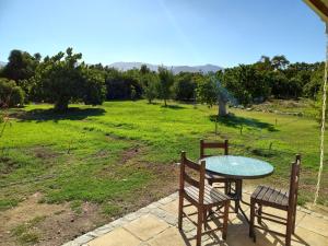 a table and chairs on a patio with a field at Casa Interior en La Cruz Quillota in Quillota