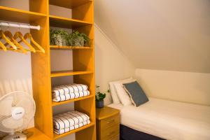 Habitación con litera y estante de libros amarillo en Hahei Beach Resort en Hahei