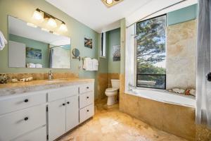 een badkamer met een wastafel, een bad en een raam bij Starboard Sunset in Bodega Bay