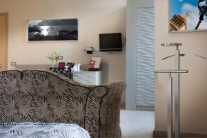 Una sala de estar con un sofá y un televisor. en Hotel Garibaldi, en Palermo