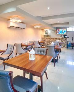 um restaurante com mesas e cadeiras e um balcão em Malecon Rooms y Hotel em Santo Domingo