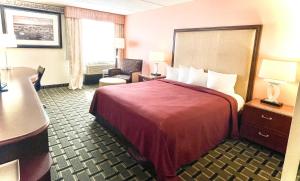 a hotel room with a bed and a desk at Fairbridge Hotel Cleveland East in Wickliffe