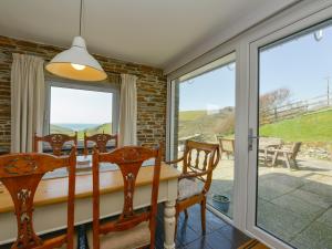 a dining room with a table and chairs and sliding glass doors at Ayrmer House in Bigbury