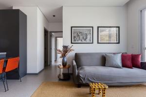 sala de estar con sofá gris y sillas naranjas en Cobertura Jardins | AC | Garagem, en São Paulo