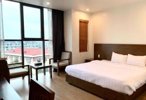 a bedroom with a bed and a large window at HOTEL Blue Rose in Hai Phong