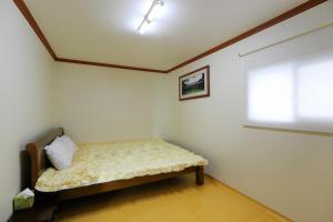 a bedroom with a bed in a room with a window at Pension Seoak in Gyeongju
