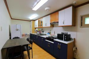 a kitchen with blue cabinets and a table in it at Pension Seoak in Gyeongju