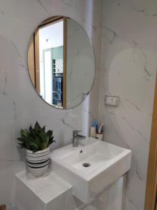 een witte badkamer met een wastafel en een spiegel bij GRAND HYCHARMS Serviced 2BR APARTMENT View Cầu Nhơn Hội in Quy Nhon