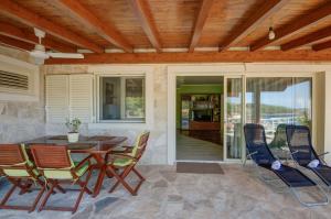 a patio with a wooden ceiling and a table and chairs at Apartment VILA GRSCICA in Blato