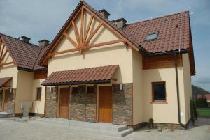 a house with a brown roof at Apartament Ostoja in Szczawnica