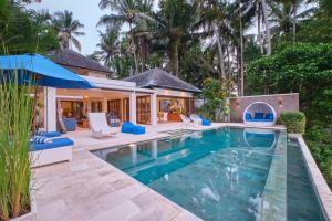 una imagen de una piscina frente a una casa en Villa Balinese Luxurious Elegance en Ubud