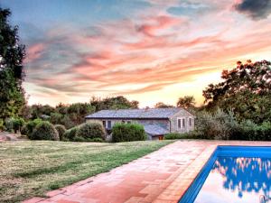 a house with a swimming pool in front of a yard at Agriturismo Il Cornalino in Castel Viscardo