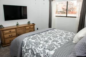 コロラドスプリングスにあるLovely 2 bedroom! Close to All in a 4Plexのベッドルーム1室(ベッド1台、ドレッサー、テレビ付)
