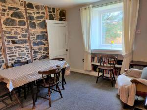 een kamer met een tafel en stoelen en een raam bij Ornum in Skerray